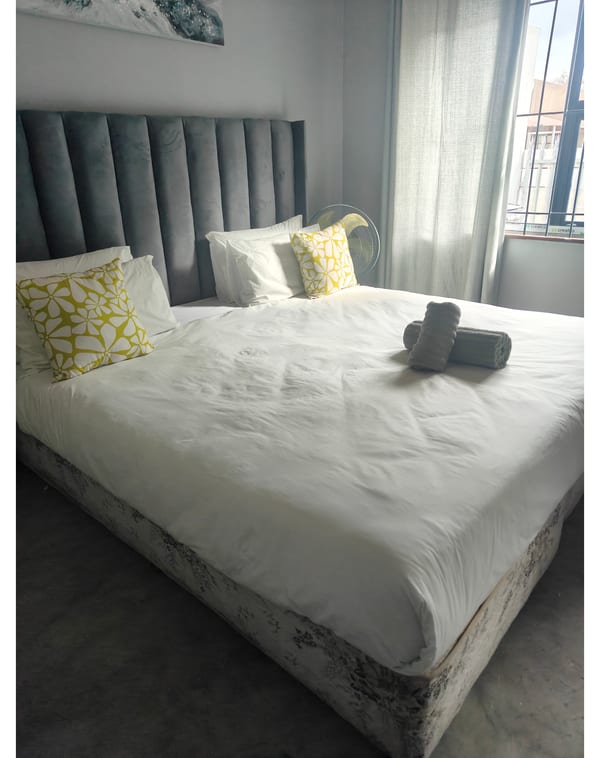 Standard double room with upholstered headboard and white bedding