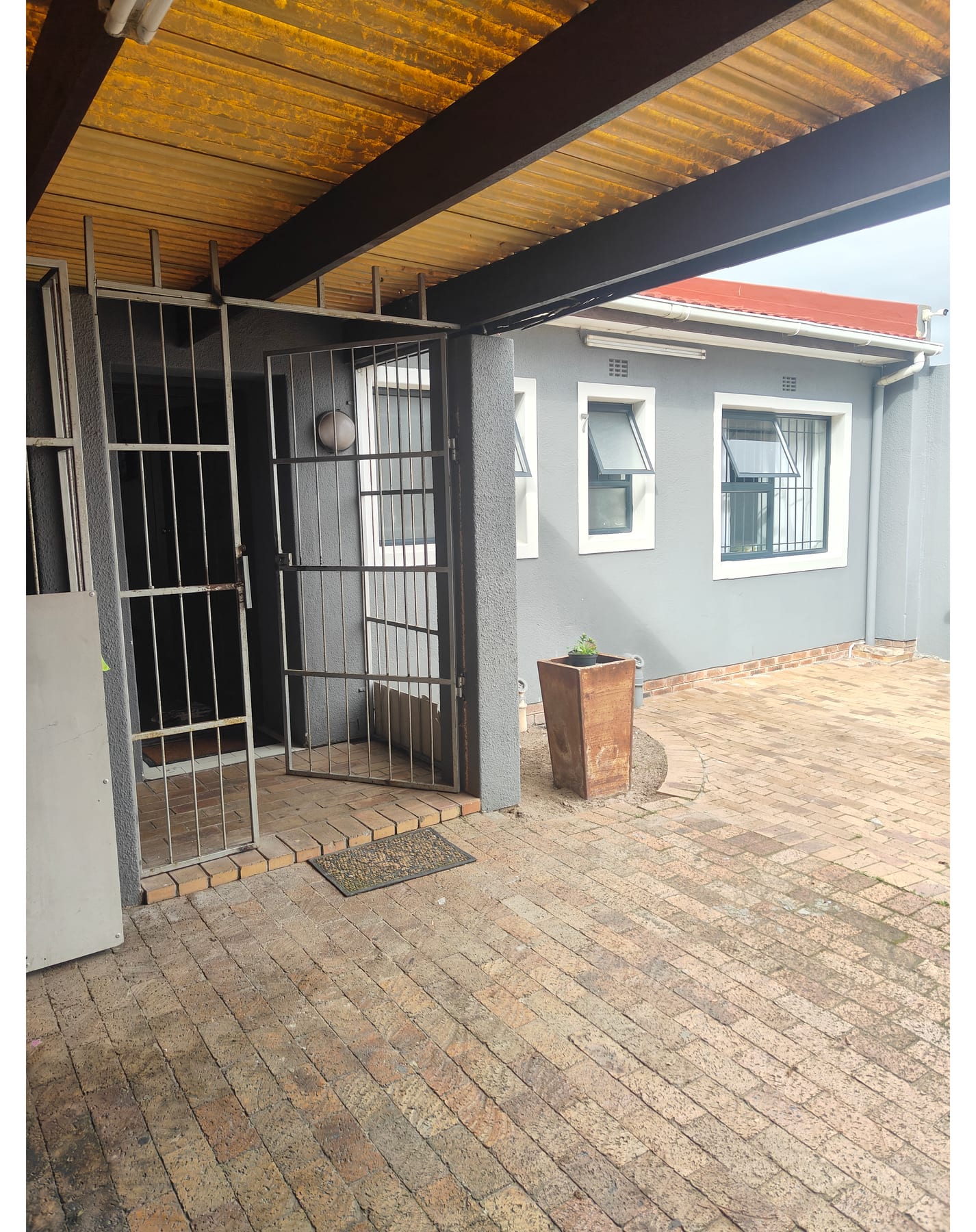 The covered entrance and paved courtyard at Global Nest Guest House
